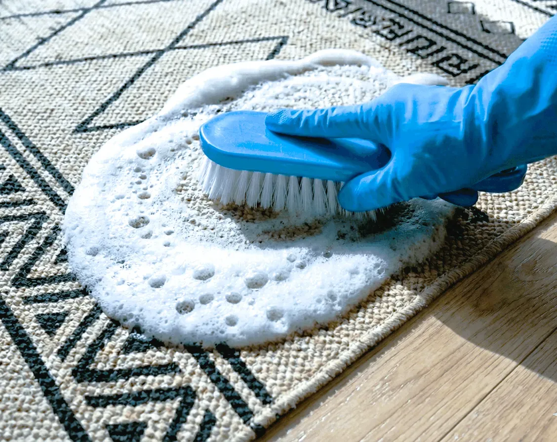 Proceso manual de lavado de alfombras con cepillo y espuma activa: tratamiento cuidadoso para fibras delicadas y eliminación de manchas específicas